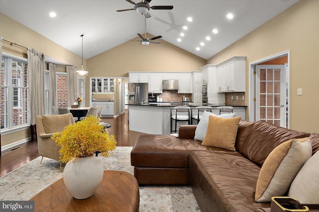 living area with visible vents, recessed lighting, wood finished floors, ceiling fan, and high vaulted ceiling