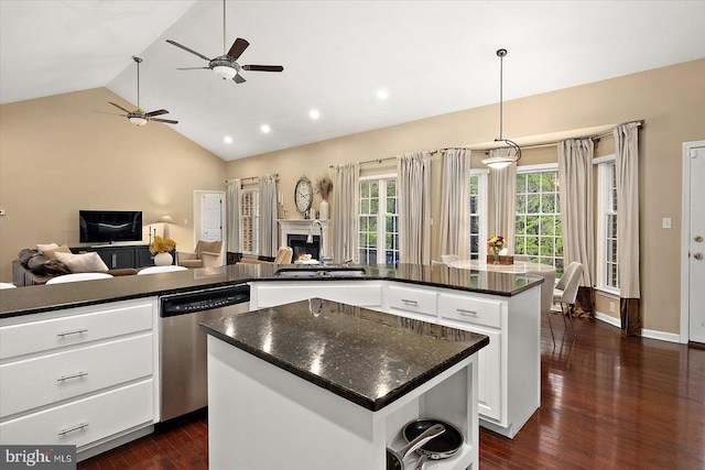 kitchen featuring a center island, stainless steel dishwasher, a healthy amount of sunlight, vaulted ceiling, and ceiling fan