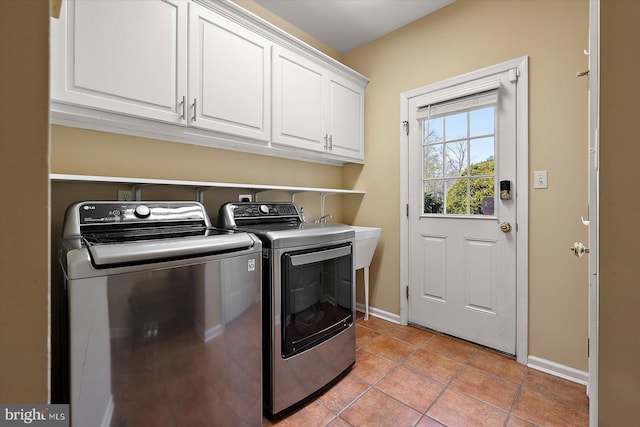 laundry room with separate washer and dryer, baseboards, cabinet space, and light tile patterned floors