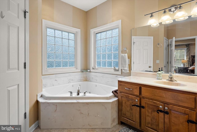 full bathroom featuring a garden tub, vanity, tile patterned floors, and plenty of natural light