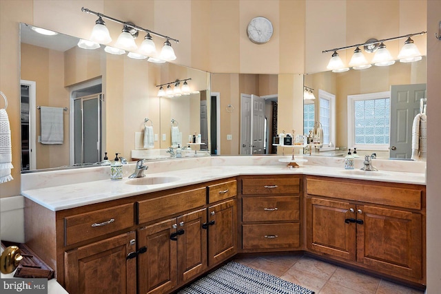 full bathroom with tile patterned floors, a towering ceiling, a sink, and double vanity