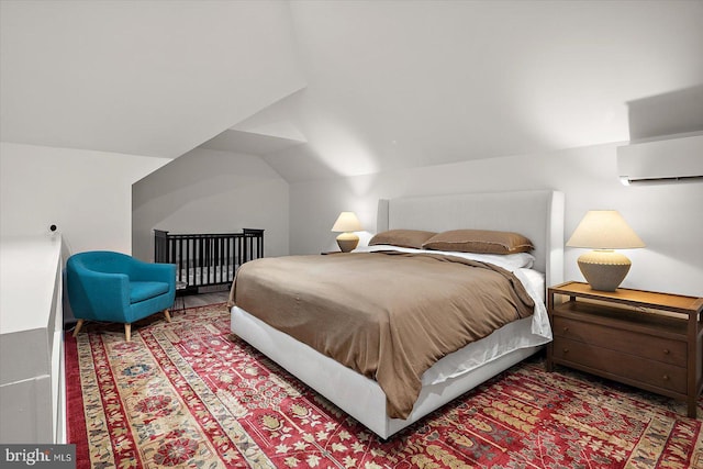 bedroom featuring an AC wall unit and lofted ceiling