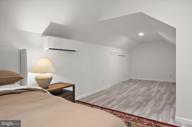 bedroom with a wall unit AC, baseboards, recessed lighting, lofted ceiling, and wood finished floors