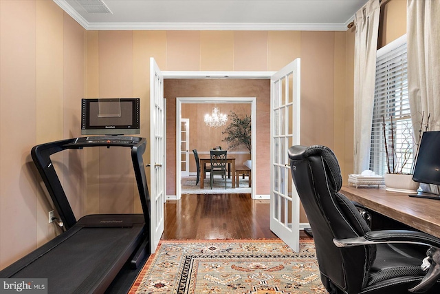 office featuring wood finished floors, an inviting chandelier, baseboards, ornamental molding, and visible vents