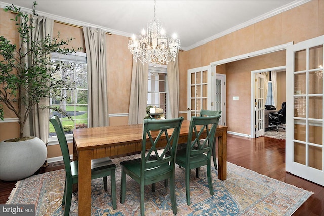 dining room featuring an inviting chandelier, wood finished floors, ornamental molding, french doors, and baseboards