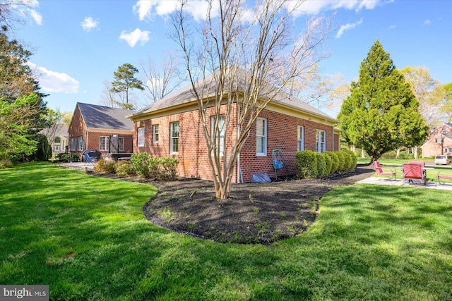 exterior space with brick siding and a yard