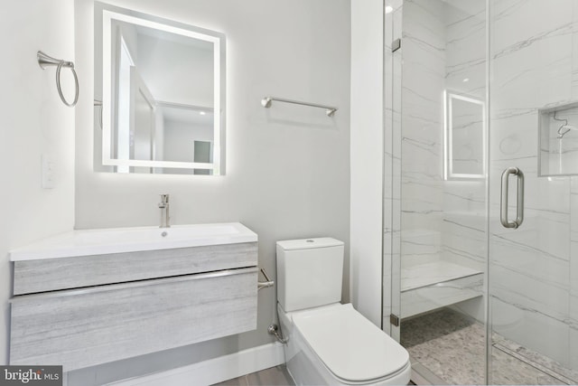 bathroom with a marble finish shower, vanity, and toilet