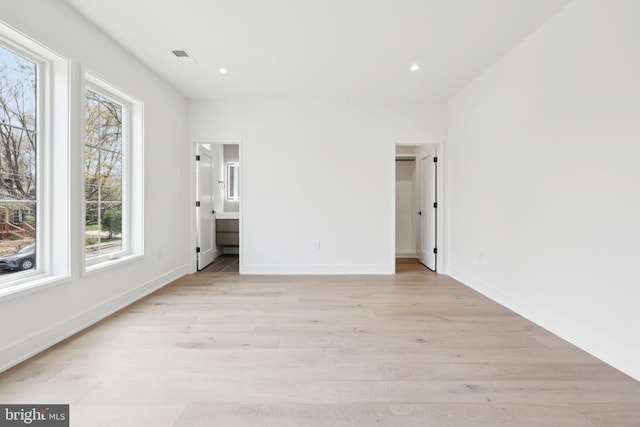 unfurnished bedroom with light wood finished floors, baseboards, recessed lighting, and multiple windows