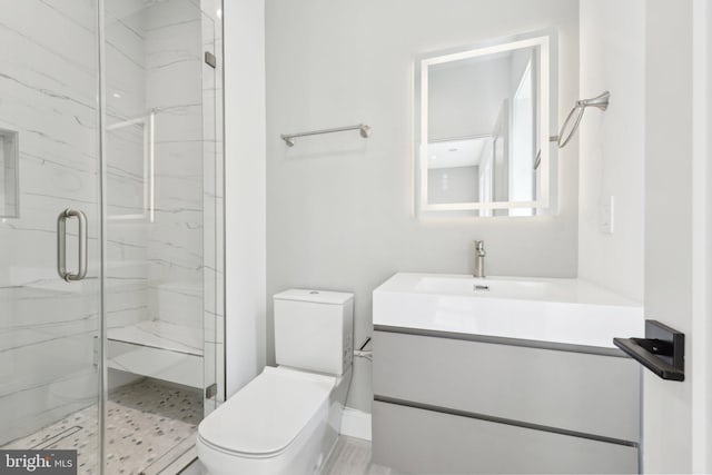 bathroom featuring toilet, vanity, and a marble finish shower