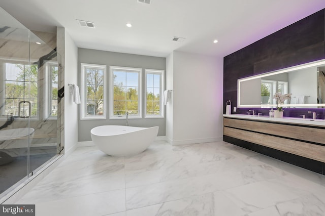 bathroom with marble finish floor, vanity, a marble finish shower, baseboards, and a soaking tub