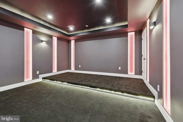 cinema with carpet, baseboards, visible vents, and a raised ceiling