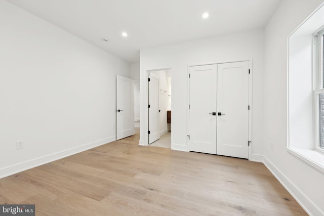 unfurnished bedroom with light wood-style flooring, baseboards, and recessed lighting