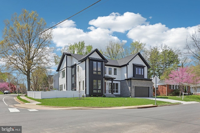 view of front of home with an attached garage, a front yard, fence, and driveway