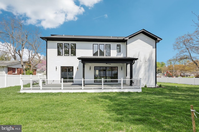 rear view of house featuring a lawn and a fenced backyard