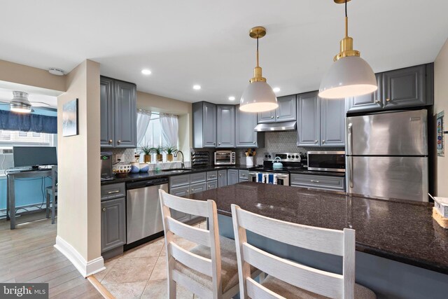 111 W 18th St Unit 2, Ship Bottom, NJ 08008 - kitchen featuring under cabinet range hood, stainless steel appliances, gray cabinetry, and decorative backsplash