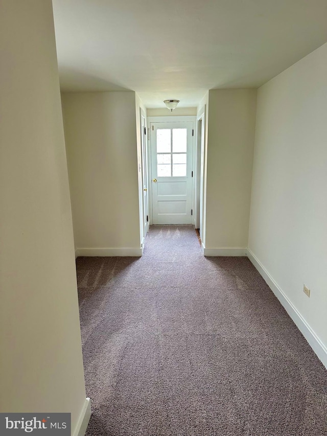 unfurnished room with baseboards and carpet floors