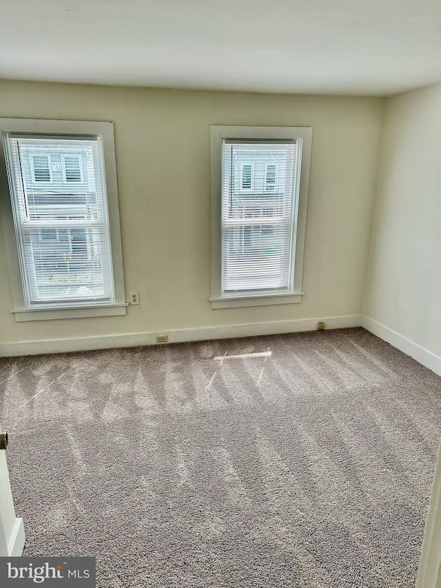 carpeted spare room with baseboards