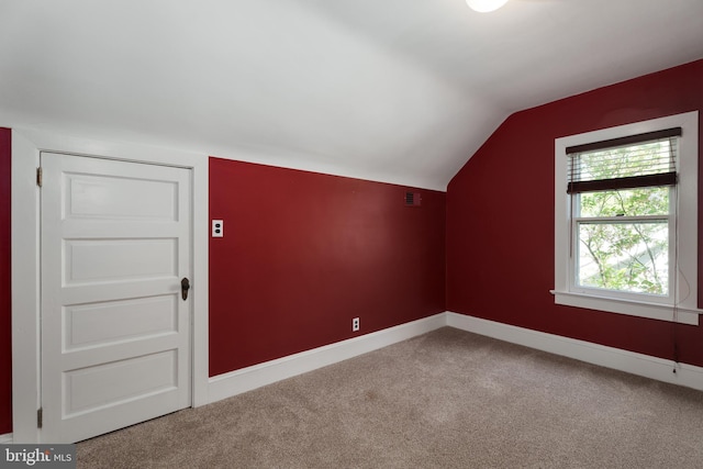 additional living space featuring carpet, visible vents, baseboards, and lofted ceiling