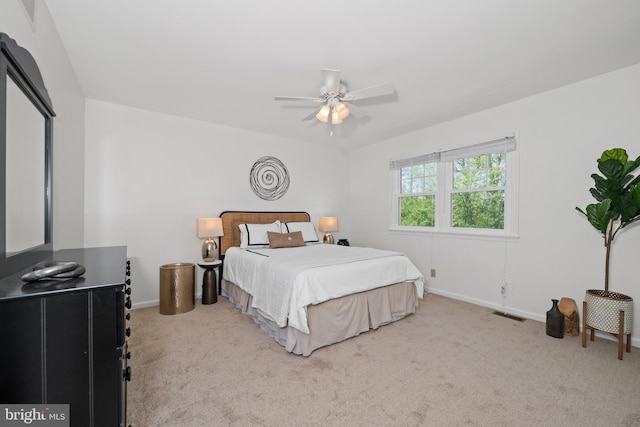 carpeted bedroom with a ceiling fan, baseboards, and visible vents