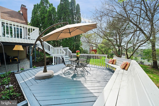wooden deck featuring outdoor dining space and stairs