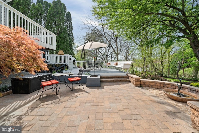 view of patio featuring outdoor dining area and a deck