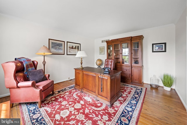 home office with baseboards, ornamental molding, and light wood finished floors