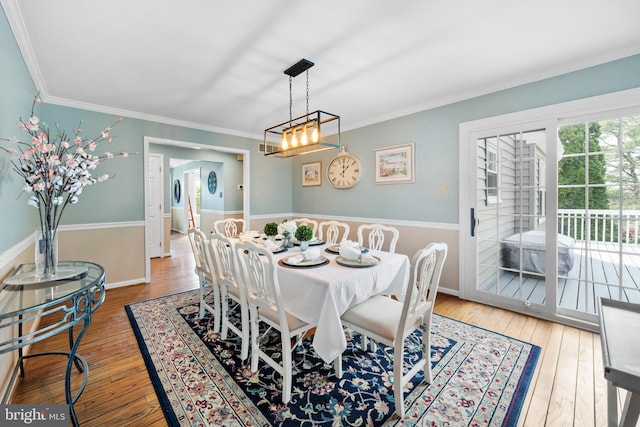 dining room with wood-type flooring and crown molding