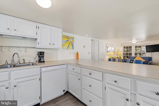 kitchen with a sink, light countertops, white cabinets, and white dishwasher
