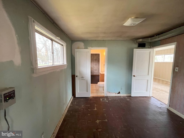 8183 Forest Glen Dr, Pasadena, MD 21122 - unfurnished bedroom with connected bathroom, baseboards, and wood finished floors