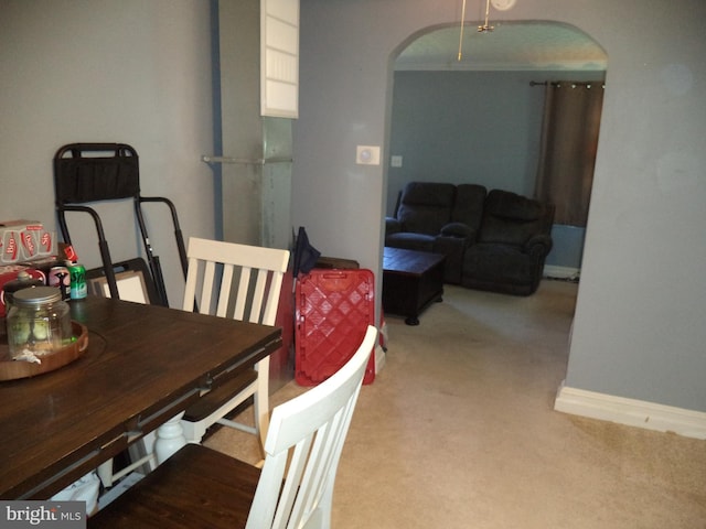 dining area featuring arched walkways, baseboards, and carpet floors