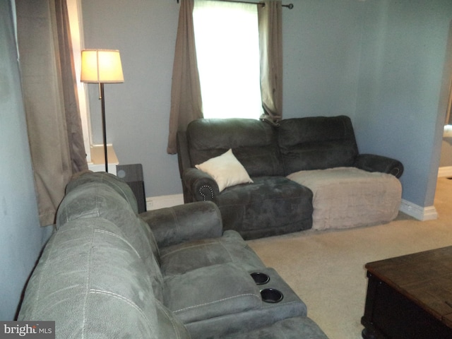 carpeted living area featuring baseboards