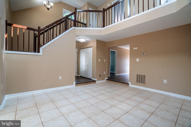 4501 Peppermill Ct, Dumfries, VA 22025 - unfurnished living room with high vaulted ceiling, tile patterned floors, baseboards, a chandelier, and stairs