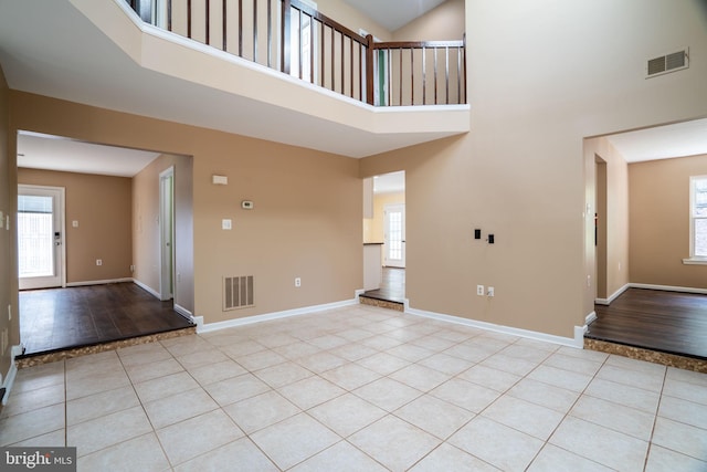 4501 Peppermill Ct, Dumfries, VA 22025 - unfurnished living room featuring a towering ceiling, light tile patterned flooring, and plenty of natural light