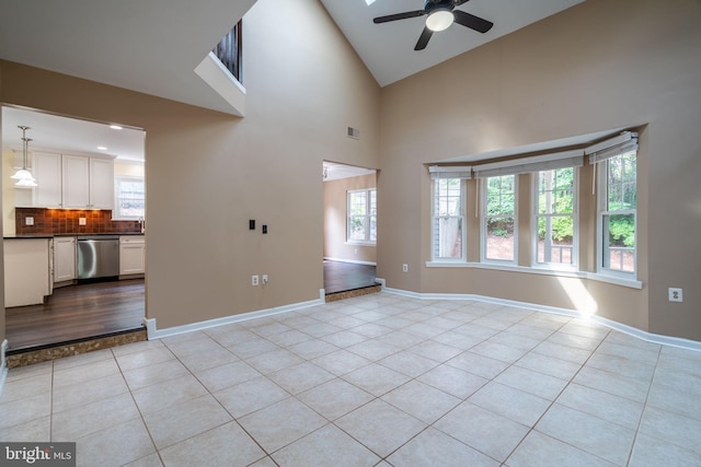 4501 Peppermill Ct, Dumfries, VA 22025 - unfurnished living room with light tile patterned floors, ceiling fan, baseboards, high vaulted ceiling, and a sink