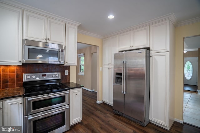 4501 Peppermill Ct, Dumfries, VA 22025 - kitchen featuring appliances with stainless steel finishes, baseboards, white cabinetry, crown molding, and tasteful backsplash