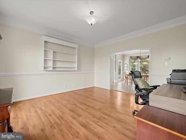 office area featuring arched walkways, wood finished floors, baseboards, and ornamental molding