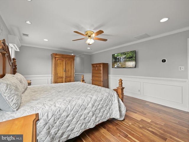 bedroom featuring recessed lighting, wood finished floors, visible vents, and a wainscoted wall
