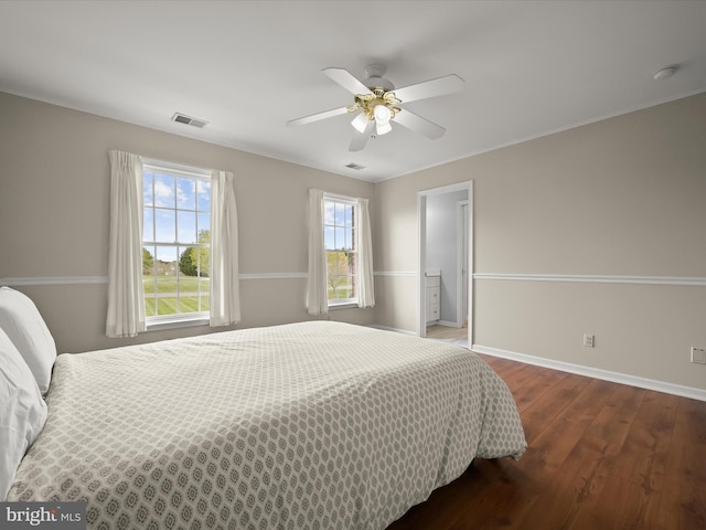 bedroom with hardwood / wood-style flooring, ceiling fan, baseboards, and visible vents