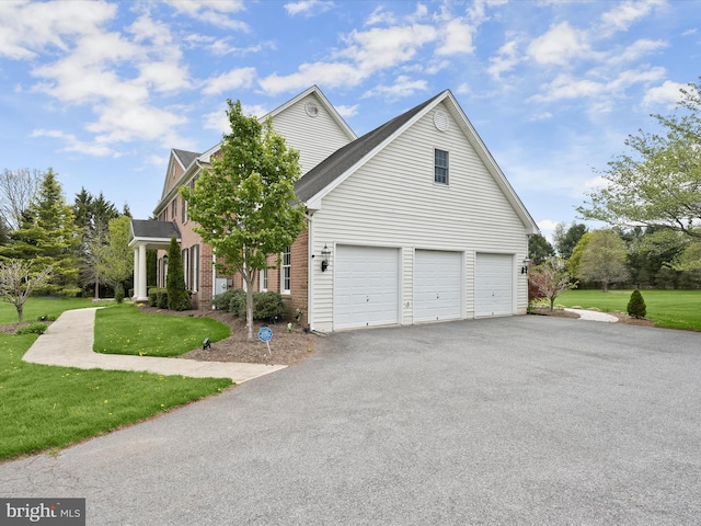 exterior space featuring driveway, brick siding, and a yard