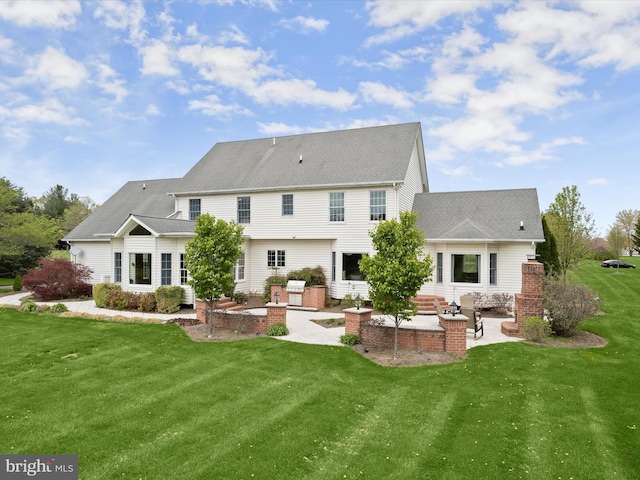 rear view of property featuring a patio area, roof with shingles, and a yard