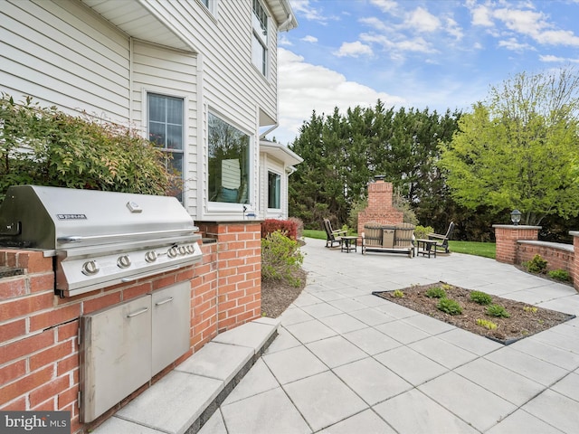 view of patio / terrace featuring a fireplace, exterior kitchen, and grilling area