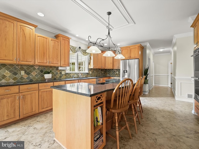 kitchen with crown molding, tasteful backsplash, a sink, and a kitchen island