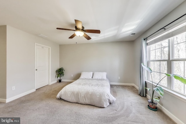 carpeted bedroom with multiple windows, baseboards, and a ceiling fan