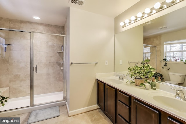 bathroom with toilet, a stall shower, tile patterned flooring, and double vanity