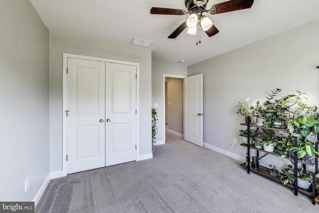carpeted bedroom with baseboards, a closet, and ceiling fan