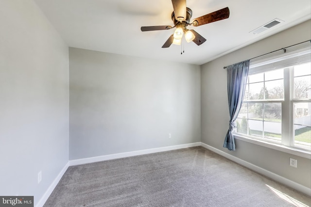 carpeted empty room featuring baseboards and ceiling fan