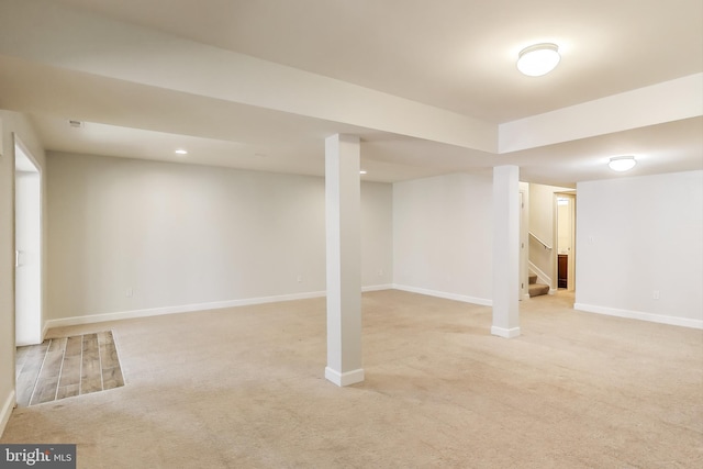finished basement featuring light carpet, baseboards, stairway, and recessed lighting