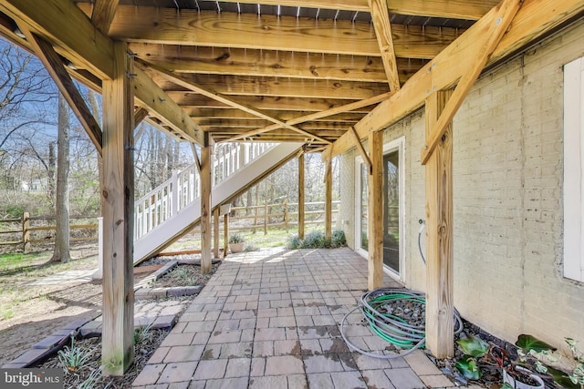 view of patio featuring stairs and fence