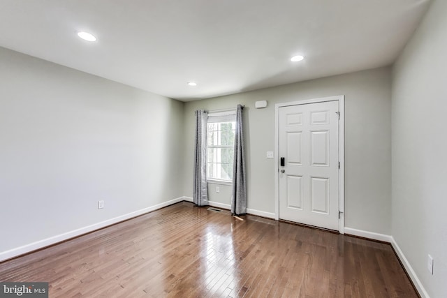 entryway with wood finished floors, baseboards, and recessed lighting