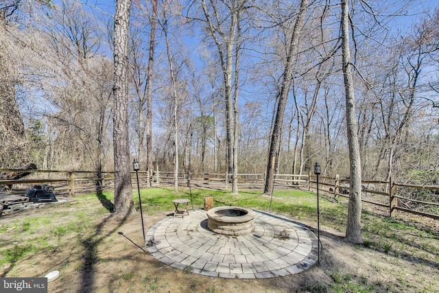 view of yard featuring an outdoor fire pit and fence